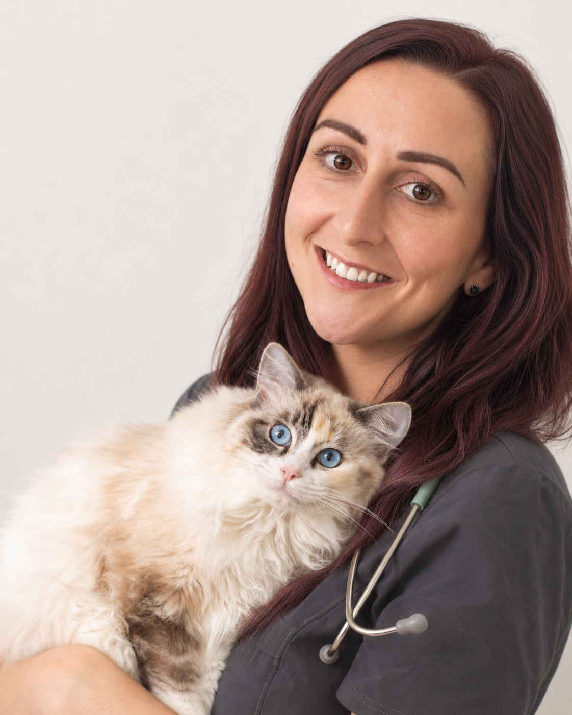 Dr Katie Ford in veterinary scrubs holding a cat