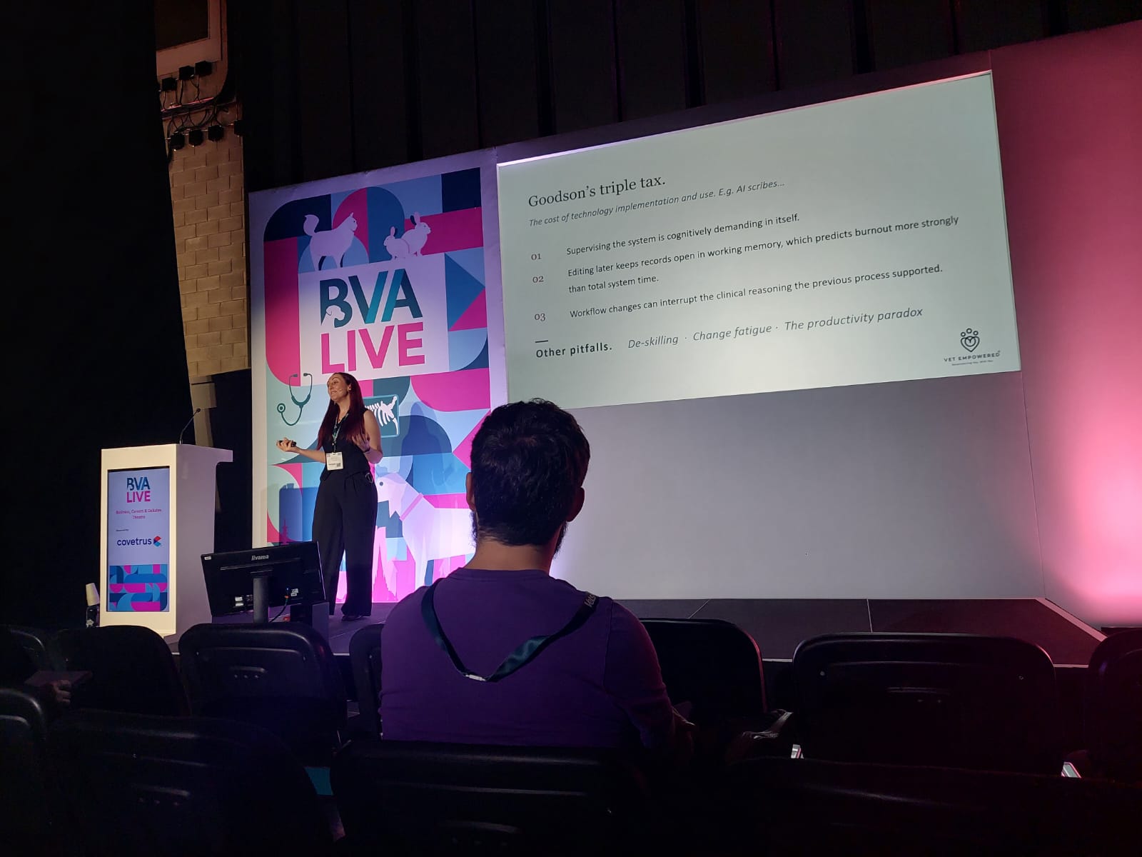 Dr Katie Ford presenting on stage to a conference audience