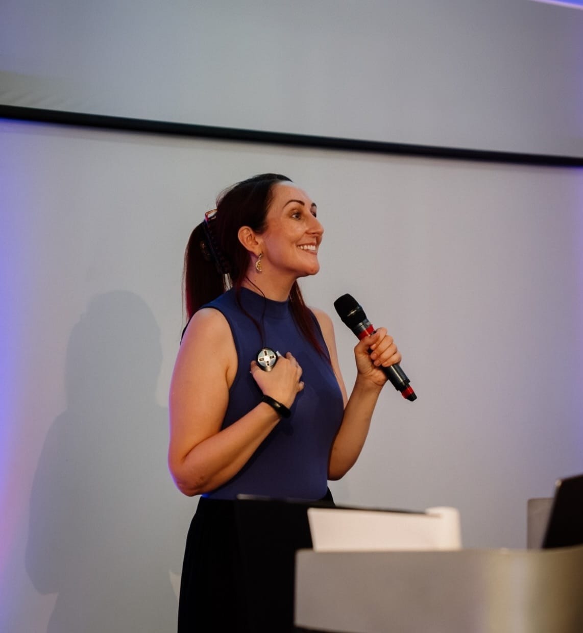 Dr Katie Ford speaking on stage with a microphone